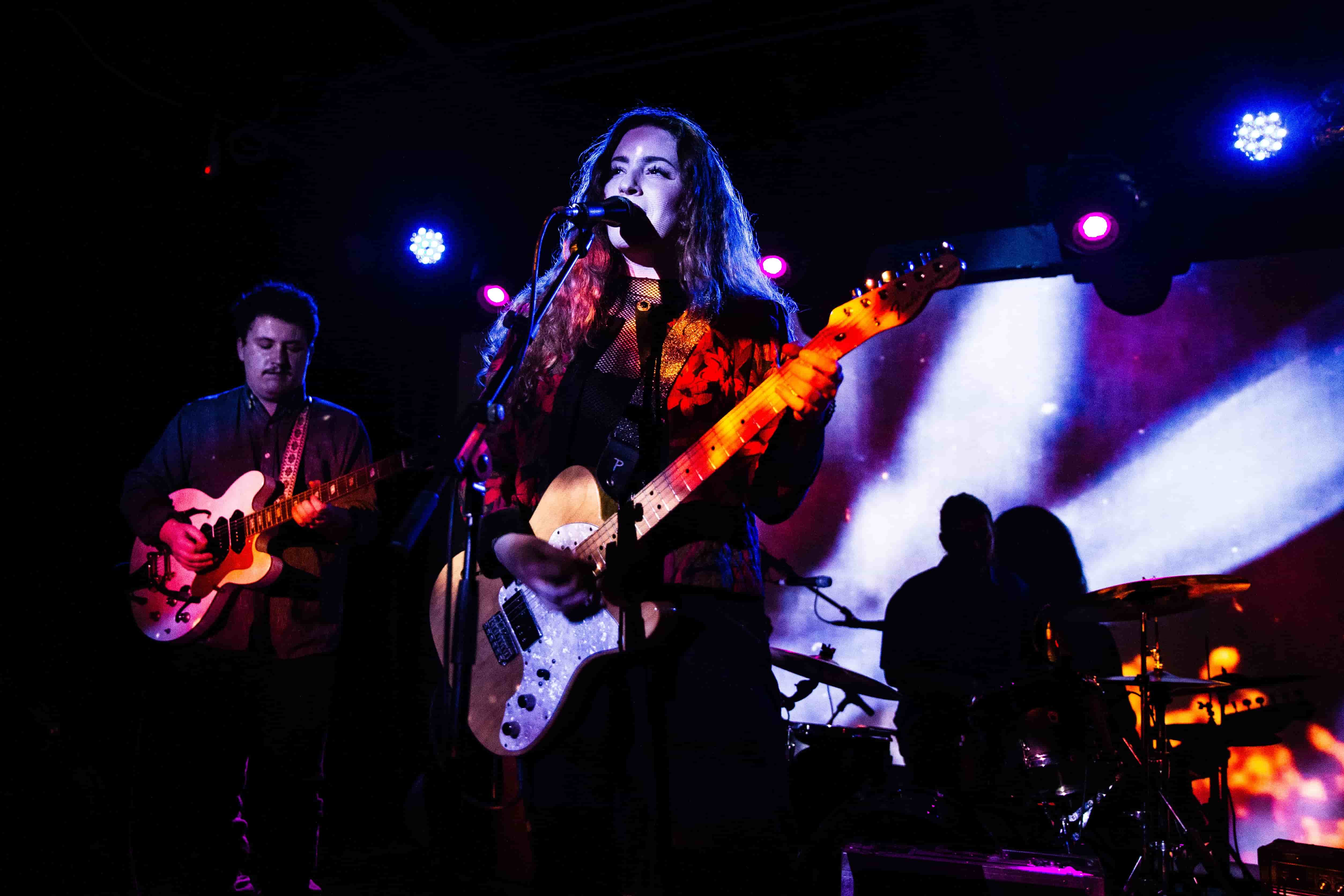 musical-band-playing-music-on-stage-with-purple-and-white